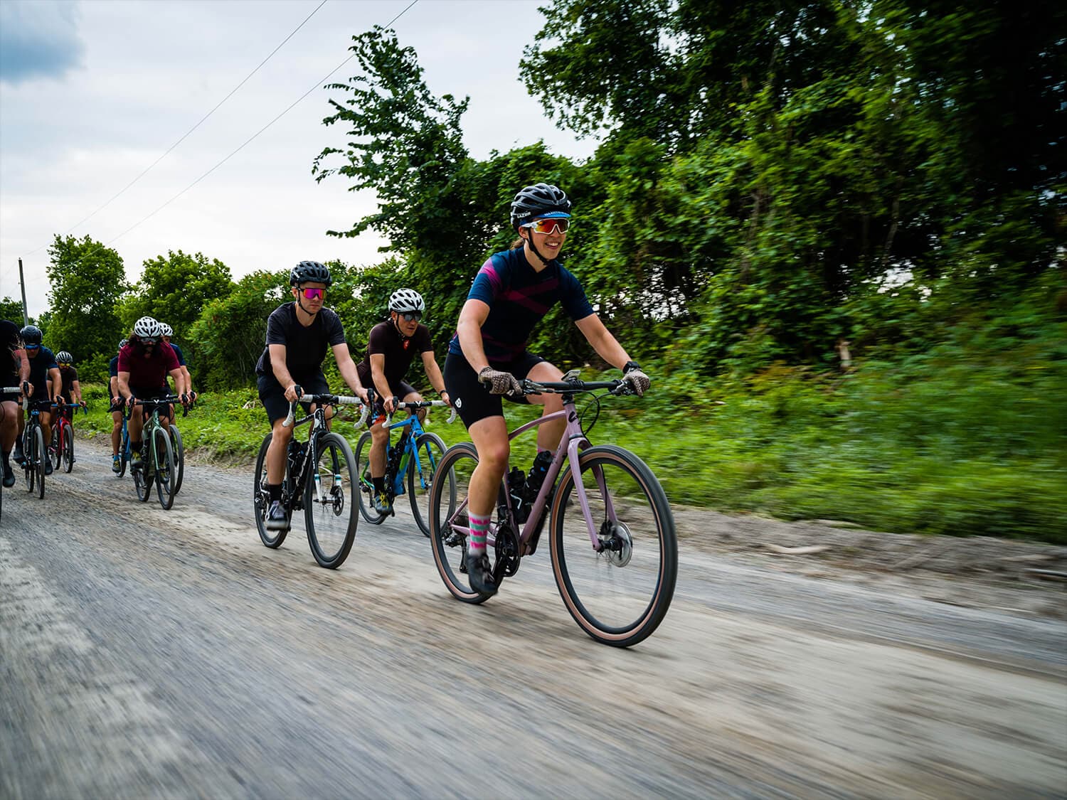 Female on pink Gravel bike leading the pack on a group gravel ride
