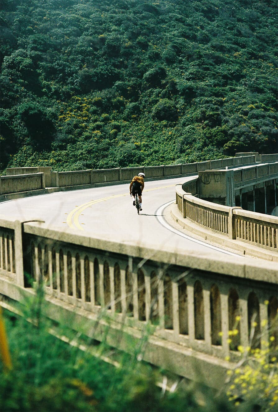 Road cyclist riding down an empty California highway 